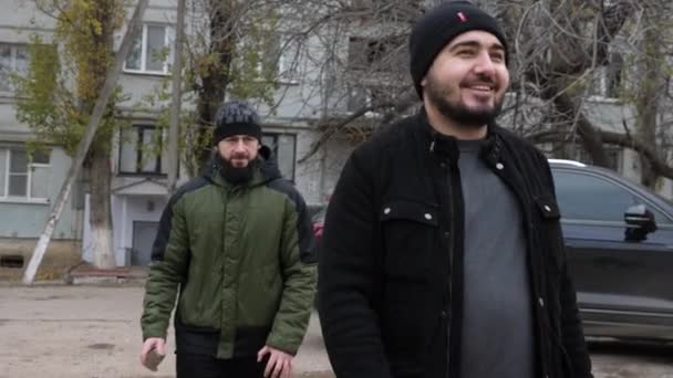 Barbudo chico en sombrero golpea sonriente hombre cabeza con gris roca — Vídeos de Stock