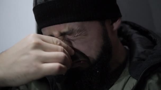 Depressed junkie with wet beard wipes eyes with hands — Stock Video