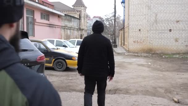 戴胡子的瘾君子跟著穿夹克的男人走在路上 — 图库视频影像