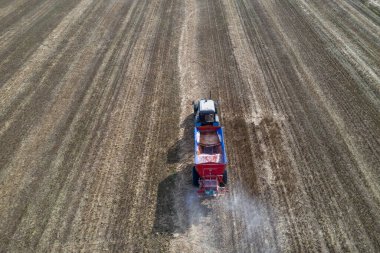 Traktör alana yapay gübre yayıyor. Üst görünüm.