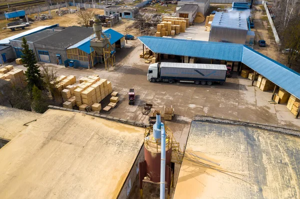 A truck is loaded with wooden products at a woodworking factory top view.