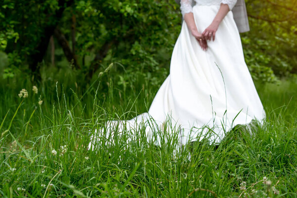 Wedding background, bride in a white dress on a green background.