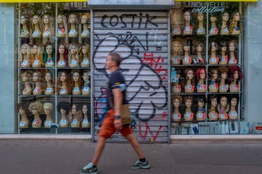 Hareket, Paris 'te peruk sallayan bir sürü mankenin bulunduğu bir dükkan penceresinin önünden geçen tanınmayan bir adamı bulanıklaştırdı.