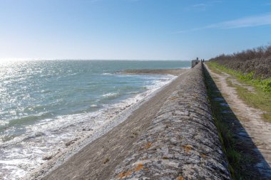 Güneşli bir kış günü Rhe Adası 'nda okyanus yıkılan duvar.
