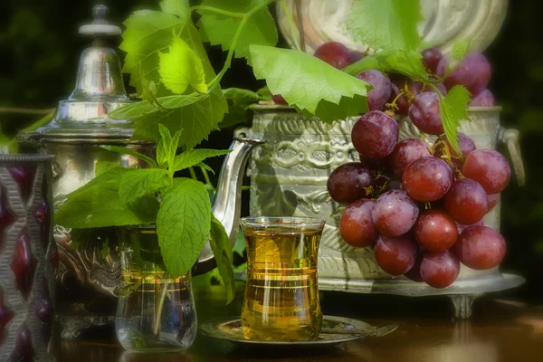 Mint te och röda druvor på Arabian bord — Stockfoto