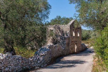 Yunanistan 'ın Paxos adasındaki yollardan birinde terk edilmiş bir ev