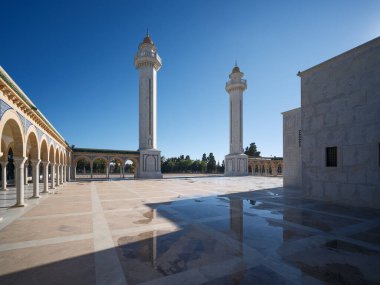 Manastır 'daki büyük Habib Bourguiba mozolesinde güneş ışığında bir yürüyüş. Altın kubbeleri ve uzun minareleri ile göz kamaştırıcı mimarisi açık mavi kış gökyüzüne karşı durarak Tunus 'un tarihini onurlandırıyor..
