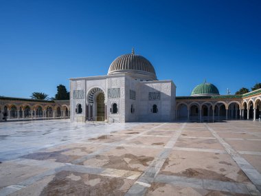 Manastır 'daki büyük Habib Bourguiba mozolesinde güneş ışığında bir yürüyüş. Altın kubbeleri ve uzun minareleri ile göz kamaştırıcı mimarisi açık mavi kış gökyüzüne karşı durarak Tunus 'un tarihini onurlandırıyor..