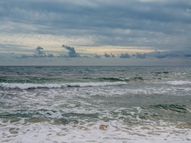 Tunus 'un sezon dışı sahillerinin barışçıl güzelliği. Dramatik kış gökyüzü boş kumsalları ve ılıman Akdeniz sularını görmezden gelerek sakin bir rahatlama ve ruhsal seyahat fotoğrafçılığı için mükemmel bir atmosfer yaratıyor..