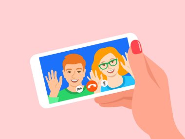 Akıllı telefondan çevrimiçi video görüşmesi. Genç çift, kız ve erkek, mobil sosyal medya uygulamasındaki arkadaşlarına merhaba diyor. Çizgi film çizimi. Koronavirüs karantinası sırasında sosyal uzaklık.