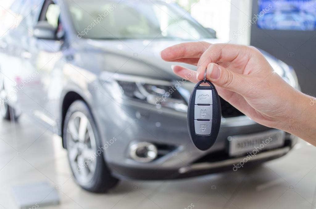 Demonstration of the keys to a new car against the car