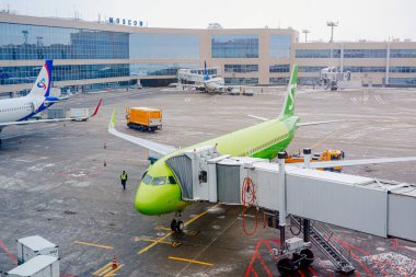 Moskova, Rusya - 16 Aralık 2020: Domodedovo Uluslararası Havalimanı, kış mevsiminde. Ural Havayolları ve S7 Havayolları yolcu terminali yakınlarındaki kapılarda.