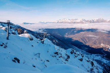 Soçi 'deki Rose Peak' ten Kafkasya Dağları manzarası. Mavi gökyüzü, bulutlar ve dağlarda beyaz kar. Yükseklik 2320 metre..