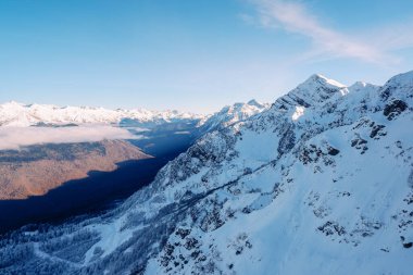 Soçi 'deki Rose Peak' ten Kafkasya Dağları manzarası. Mavi gökyüzü, bulutlar ve dağlarda beyaz kar. Yükseklik 2320 metre..