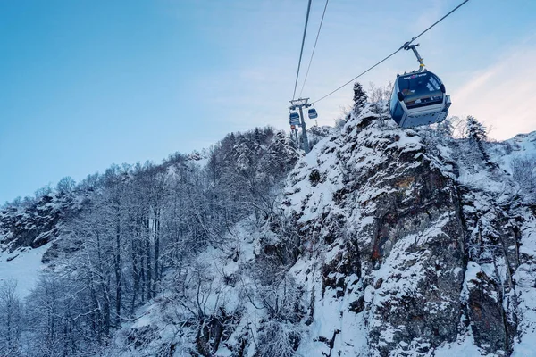 Sochi, Rusya - 18 Aralık 2020: Dağlardaki Cableway. Dağlarda mavi gökyüzüne karşı beyaz kar. Kayak merkezi Rosa Khutor, Sochi, Rusya