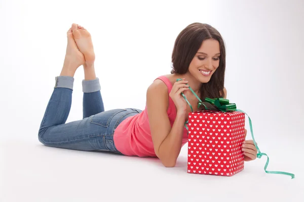 Schöne Frau in rotem T-Shirt und blauer Jeans genießt Geschenk am Valentinstag — Stockfoto