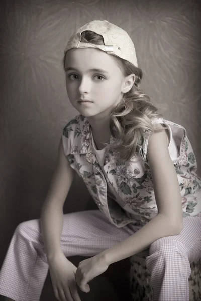 Portrait of beautiful girl in  t-shirt and trousers in the inverted cap room beforehand — Stock Photo, Image