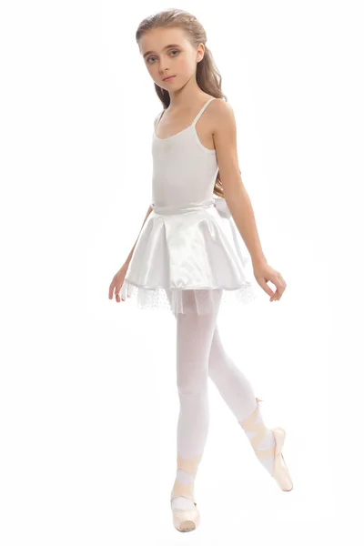 Young girl in her dance clothes reaching down to touch her foot. — Stock Photo, Image