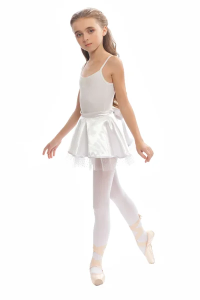 Young girl in her dance clothes reaching down to touch her foot. — Stock Photo, Image