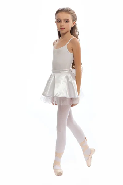 stock image young girl in her dance clothes reaching down to touch her foot.