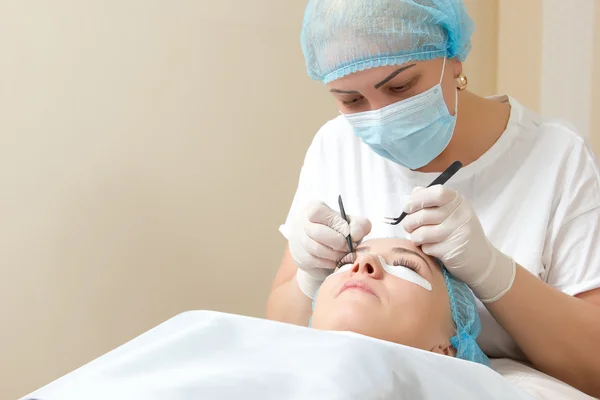 Extensión de pestañas en la tecnología de salón de belleza — Foto de Stock