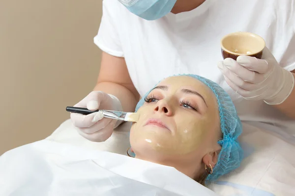 bir fırça yüz paketi ile uygulanan güzellik uzmanı