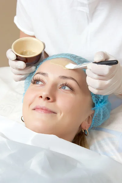 bir fırça yüz paketi ile uygulanan güzellik uzmanı