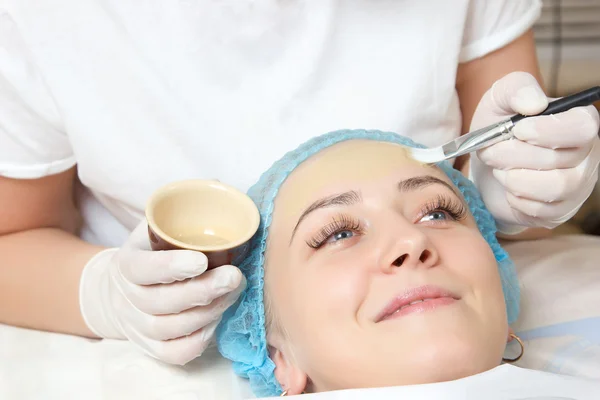 bir fırça yüz paketi ile uygulanan güzellik uzmanı