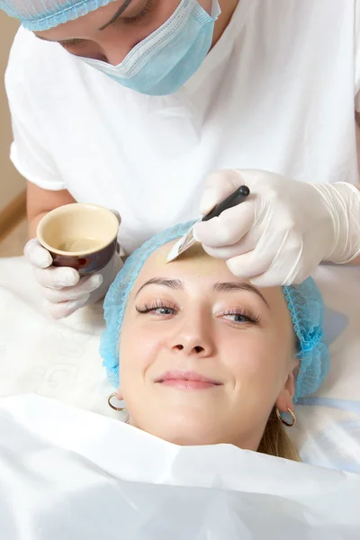 bir fırça yüz paketi ile uygulanan güzellik uzmanı