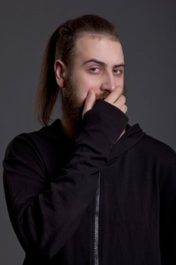 Sakallı genç adam ağzını kapsar