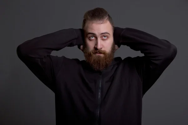 Jovem com barba cobre os ouvidos — Fotografia de Stock