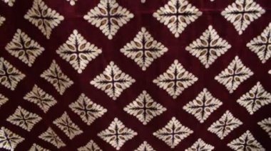 Süslü krema ve altın motiflerden yapılmış elmas desenli kadife kumaş yüzeyde düzgün sıralanmıştı. Geçmişler için kullanışlı