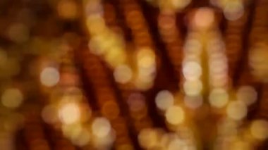 Kasıtlı olarak yüksek çözünürlüklü görüntü bulanıklaştırıyor, parlak röfleli sıcak altın ve bordo renkleri gösteriyor. Görsel efekt, nakışla süslü bir kumaşın nazikçe hareket ettiğini gösteriyor ama odak noktası yumuşak..