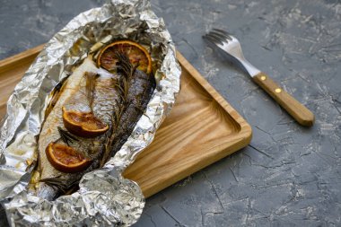 Folyoyla pişirilmiş deniz ürünleri tabağı. Biberiye ve narenciye mevsimi. Aile toplantısı için barbekü balığı.