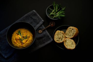 Tatlı patates, patates püresi çorbası ve siyah pürüzsüz bir yüzeye biberiye. Tabakta beyaz ekmek dilimleri