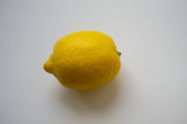 Beyaz yüzeyde tam limon meyvesi. İlkbahar enerjisi doldurmak için sarı sitrik meyvelerde vitaminler.