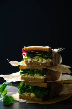 Hindiba ve mısır salatası, avokado ve salatalık dilimli vejetaryen piknik sandviçi.