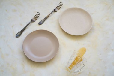 Kahvaltı için bir masaya çatal ve iki tabak. Ya da şeffaf bir bardaktan masaya çay döküldü.