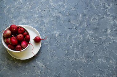 Birçok kök sebze gri yüzeyde beyaz kasede pembedir. Bahar vitaminleri bağışıklık için.