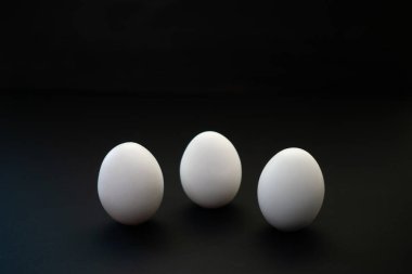 Siyah arka planda haşlanmış ya da çiğ tavuk yumurtası. Katranlı rulo ile sağlıklı dengeli yemek.