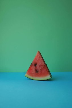 Mavi ve yeşil arka planda olgun bir karpuz dilimi. Sıcak yaz meyvelerini tazeliyorum.