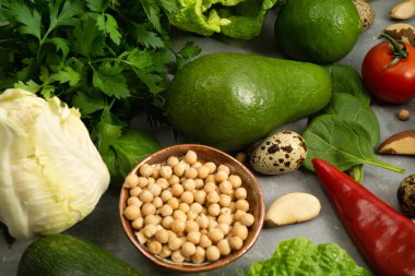 Sağlıklı beslenmek için avokado, nohut, fındık ve otlu taze sağlıklı sebzeler. Lifli ve sebze proteinleriyle dengeli bir diyet.