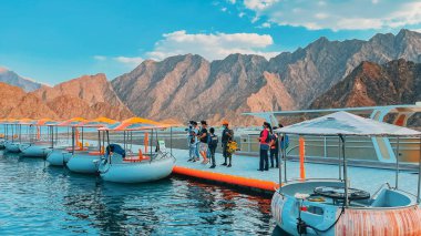 Dubai, Birleşik Arap Emirlikleri - 15 Mayıs 2021: Dubai 'deki Hatta Dam Gölü' nde kayıkla gezintiden keyif alan turist, manzara ve diğer su maceralarıyla ünlü bir cazibedir..