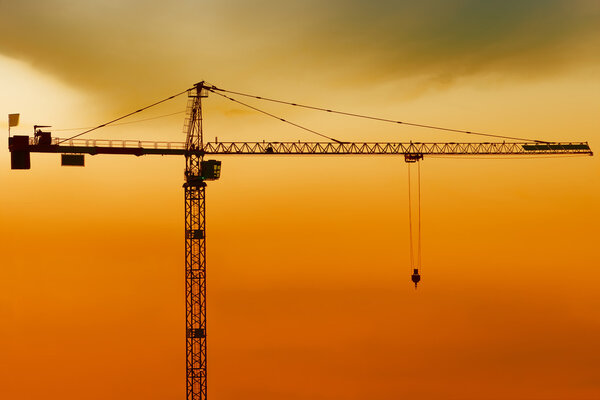 High crane silhouette on cloudy evening lighting