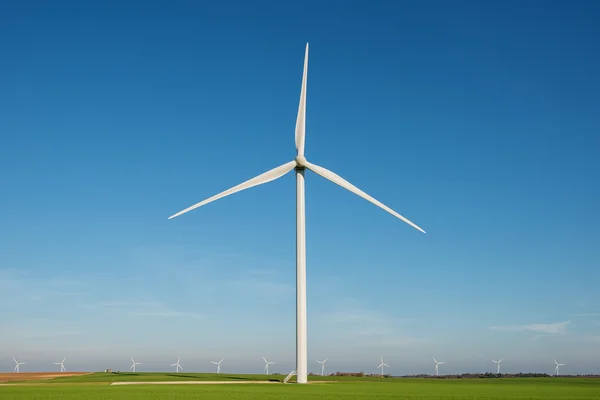 在蓝色天空背景上的风力发电机组 — 图库照片