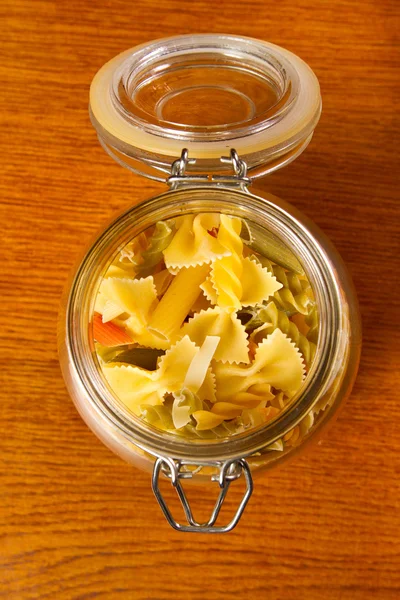 Different types of raw pasta in a glass jar — Stock Photo, Image