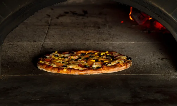 Pizza pieczenie w piecu ognia drewniane — Zdjęcie stockowe