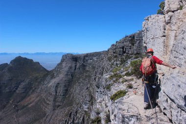 CapeTown Güney Afrika 'da tüm viteslerle cesur bir Avrupalı turist kaya tırmanışı