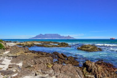 Cape Town 'da kayaları ve Atlantik okyanusu olan bir masa.