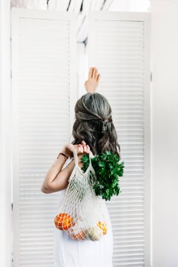 Beyaz elbiseli bir kız yiyecek, eko-çanta, yeniden kullanılabilir, kumaş torbası, vitamin, meyve ve sebze torbası, çevre dostu poşetler,